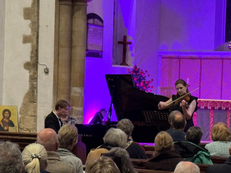 Image of Megan Hill playing violin and James Housego on Pian set in the background of St Mary's alter and chancel